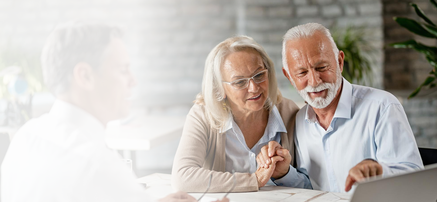 Elderly couple reviewing financial options with a licensed advisor, emphasizing personalized insurance and retirement planning services.